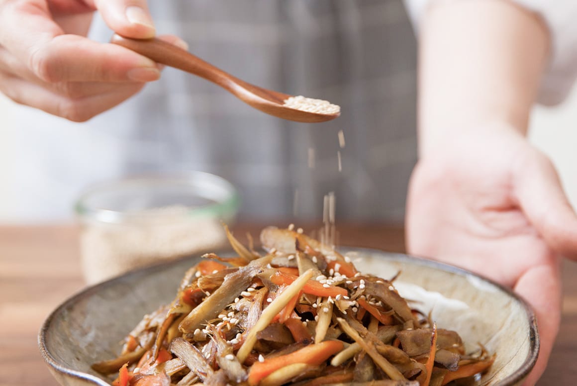 料理にごまをかけている人
